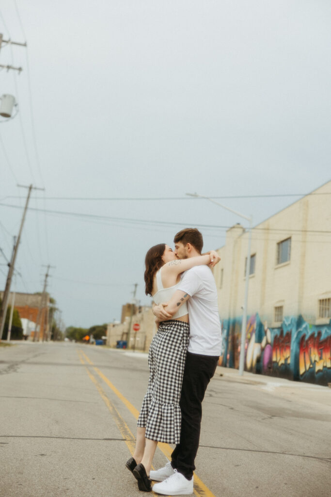 Couple kissing in the middle of an empty road during their downtown Bay City engagement photos