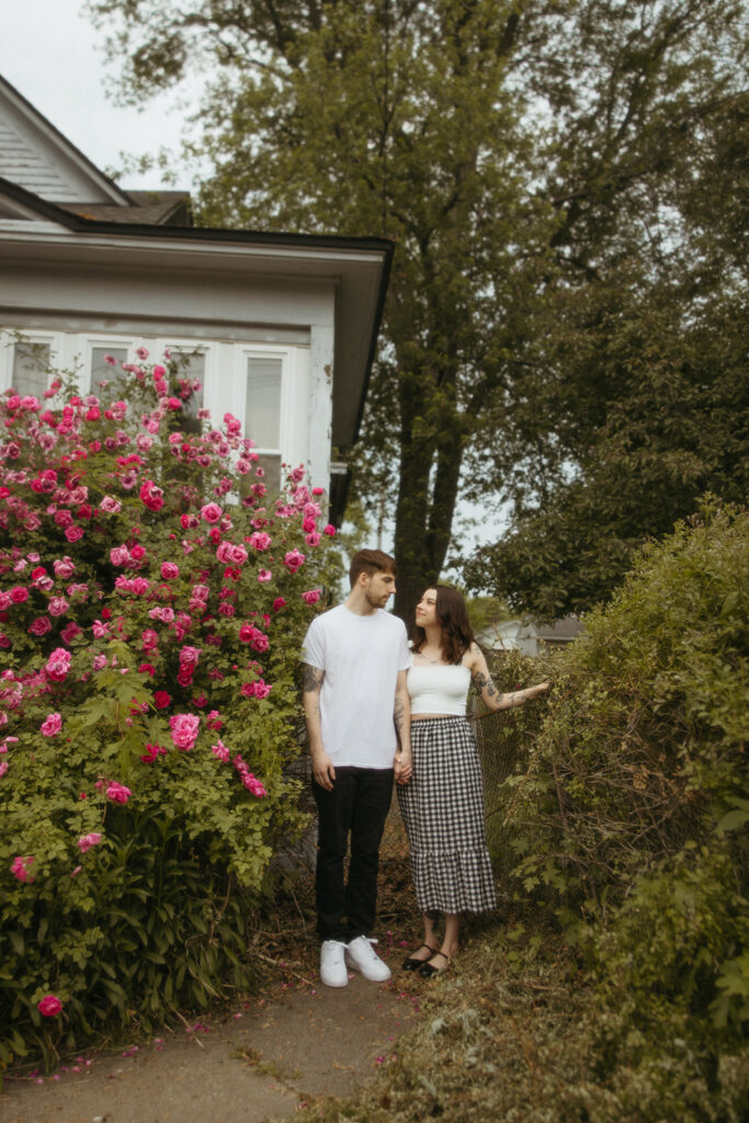 Man and woman posing for photos outside of a house in Michigan