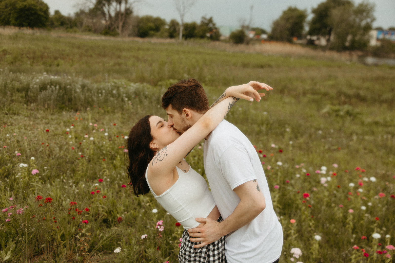 Couple kissing in a patch of wild flowers