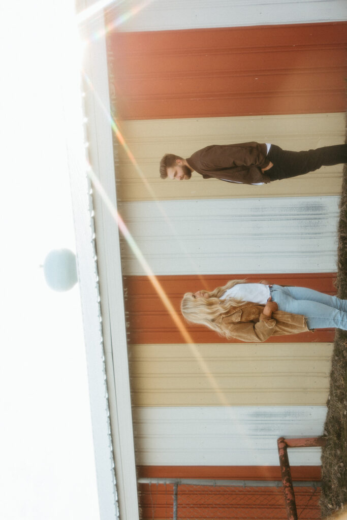 Sideways photo of a couple posing for their Midwest grunge engagement photos in Detroit, Michigan