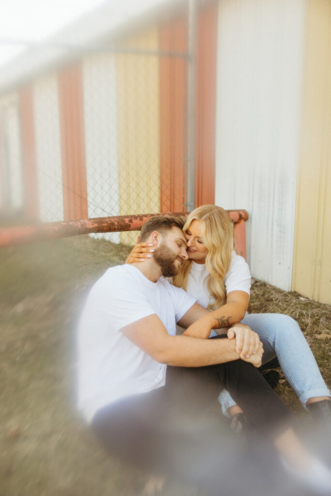 Couple sitting together for their outdoor engagement photos in Detroit. 