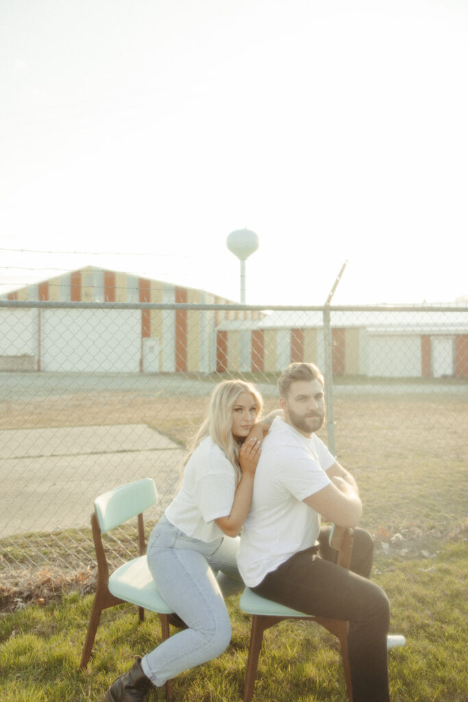 Couple sitting in chairs outside for their engagement photos in Detroit, Michigan