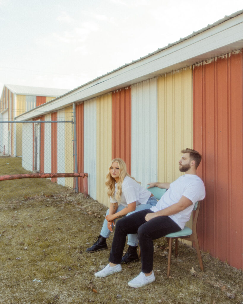 Couple sitting in chairs during their outdoor engagement photos in Detroit, Michigan