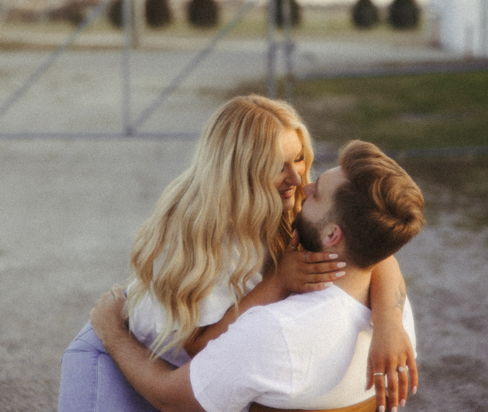 Woman going in for a kiss during her engagement photos at sunset