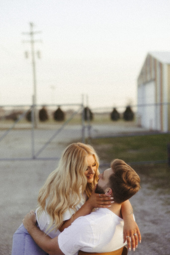 Woman straddling her fiancé in a chair for their Midwest grunge engagement shoot