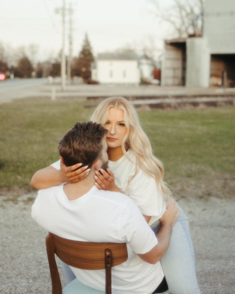 Woman straddling her fiancé in a chair for their Midwest grunge engagement photos in Detroit, Michigan