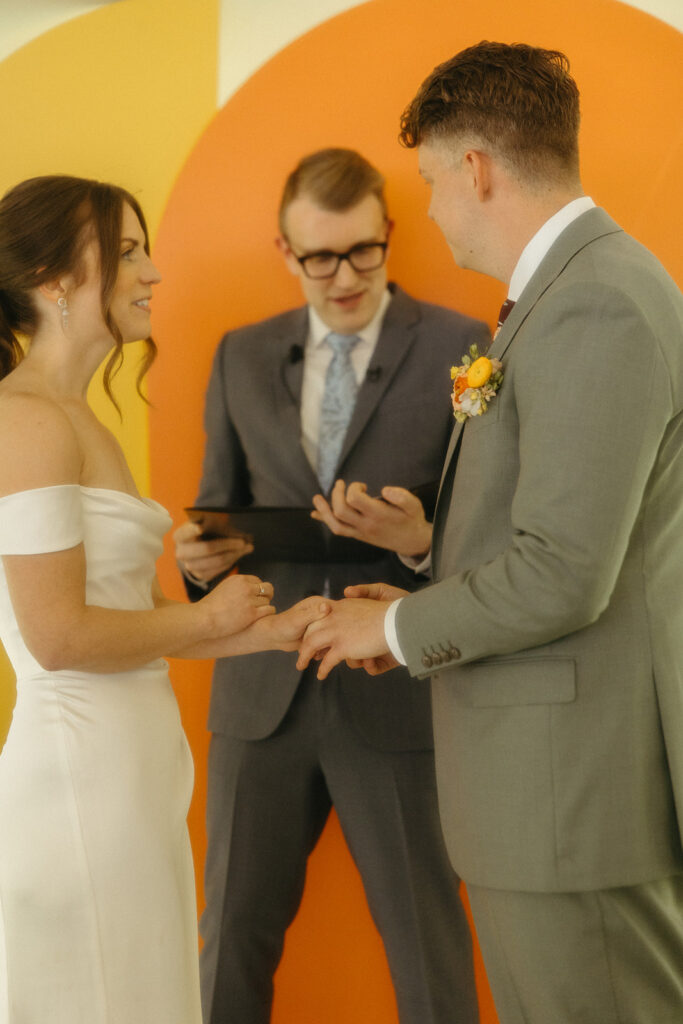 Bride and groom holding hands during their backyard Ann Arbor wedding ceremony