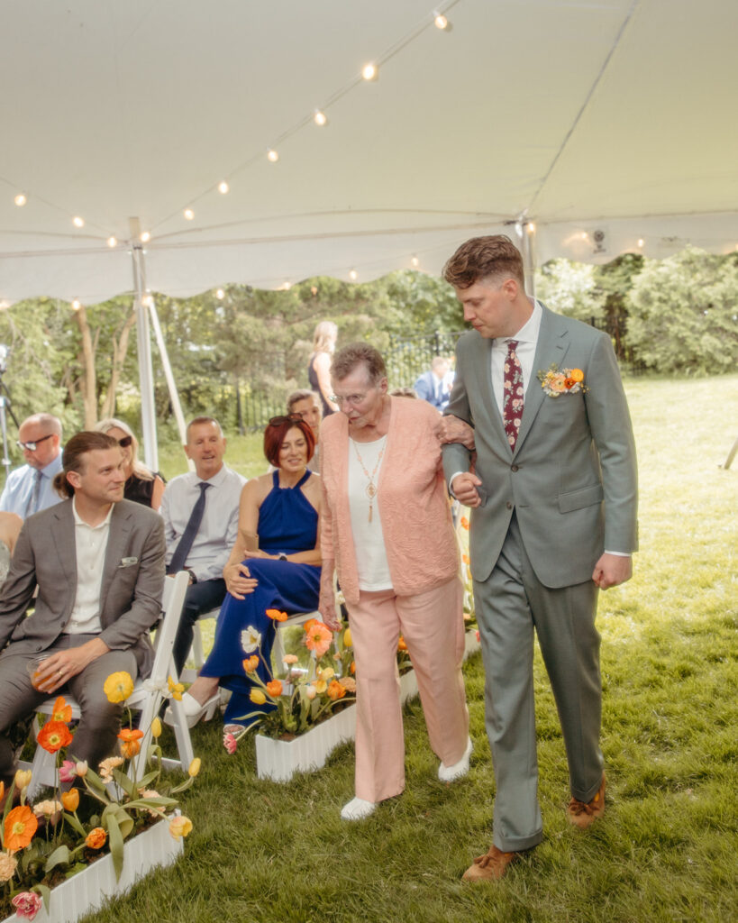 Groom walking down the aisle with his grandmother