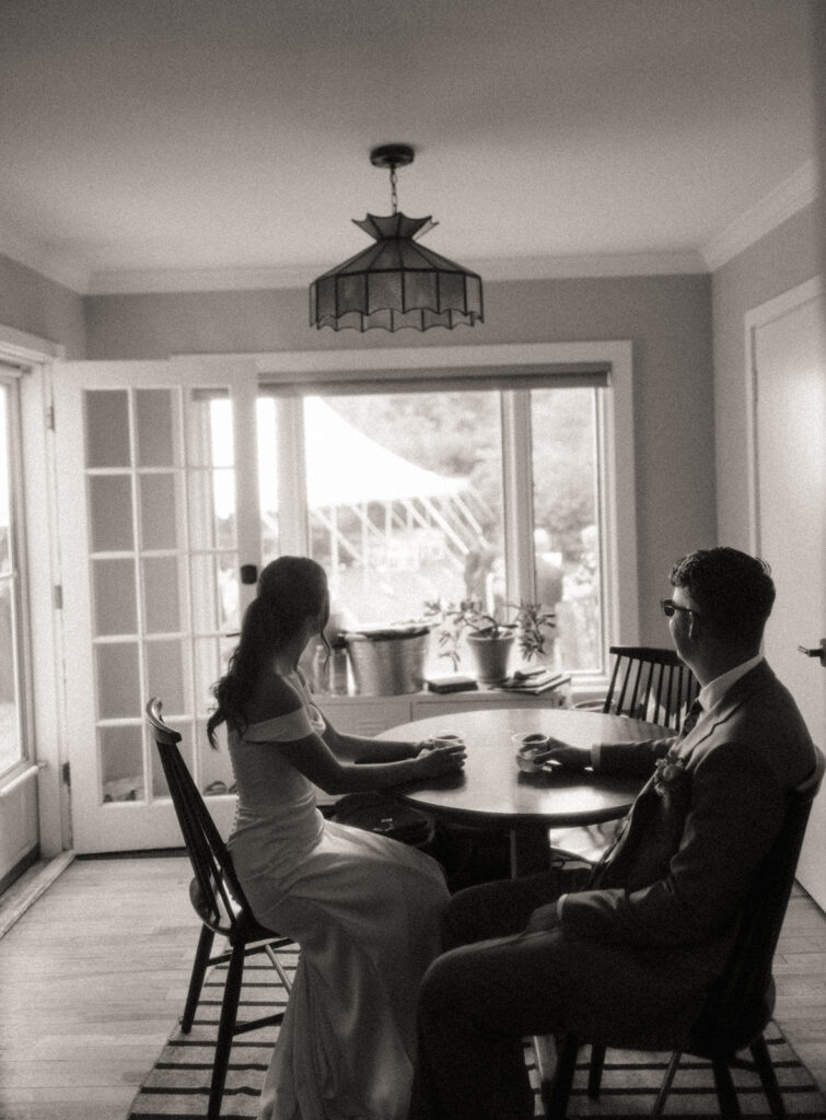 Black and white photo of a bride and groom enjoying their drinks together