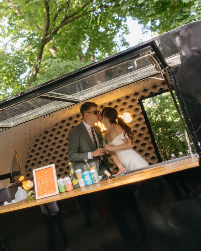 Bride and groom kissing in their Byrdie Bar trailer 