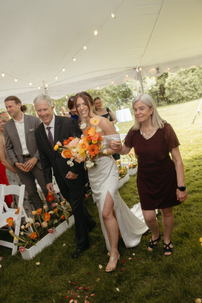 Bride walking down the aisle with her mother and father