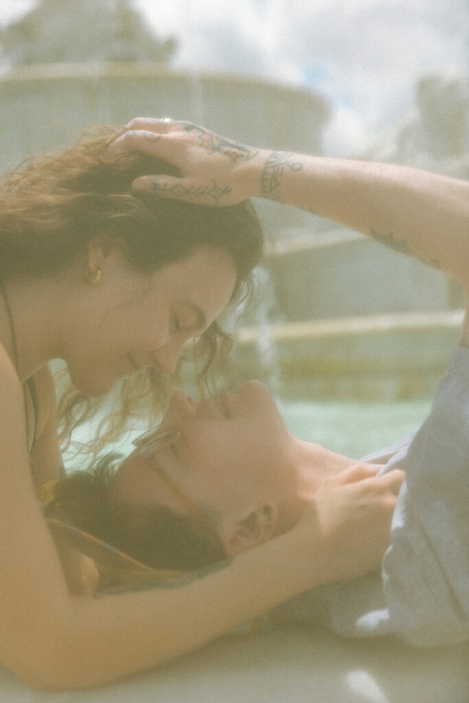 Couple going in for a kiss at the water fountain for their Belle Isle engagement photos in Detroit