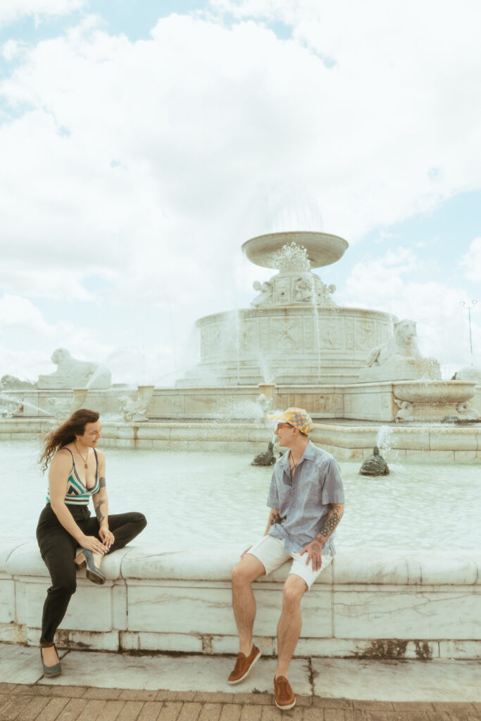 Couple sitting at the water fountain at Belle Isle for their Detroit engagement photos