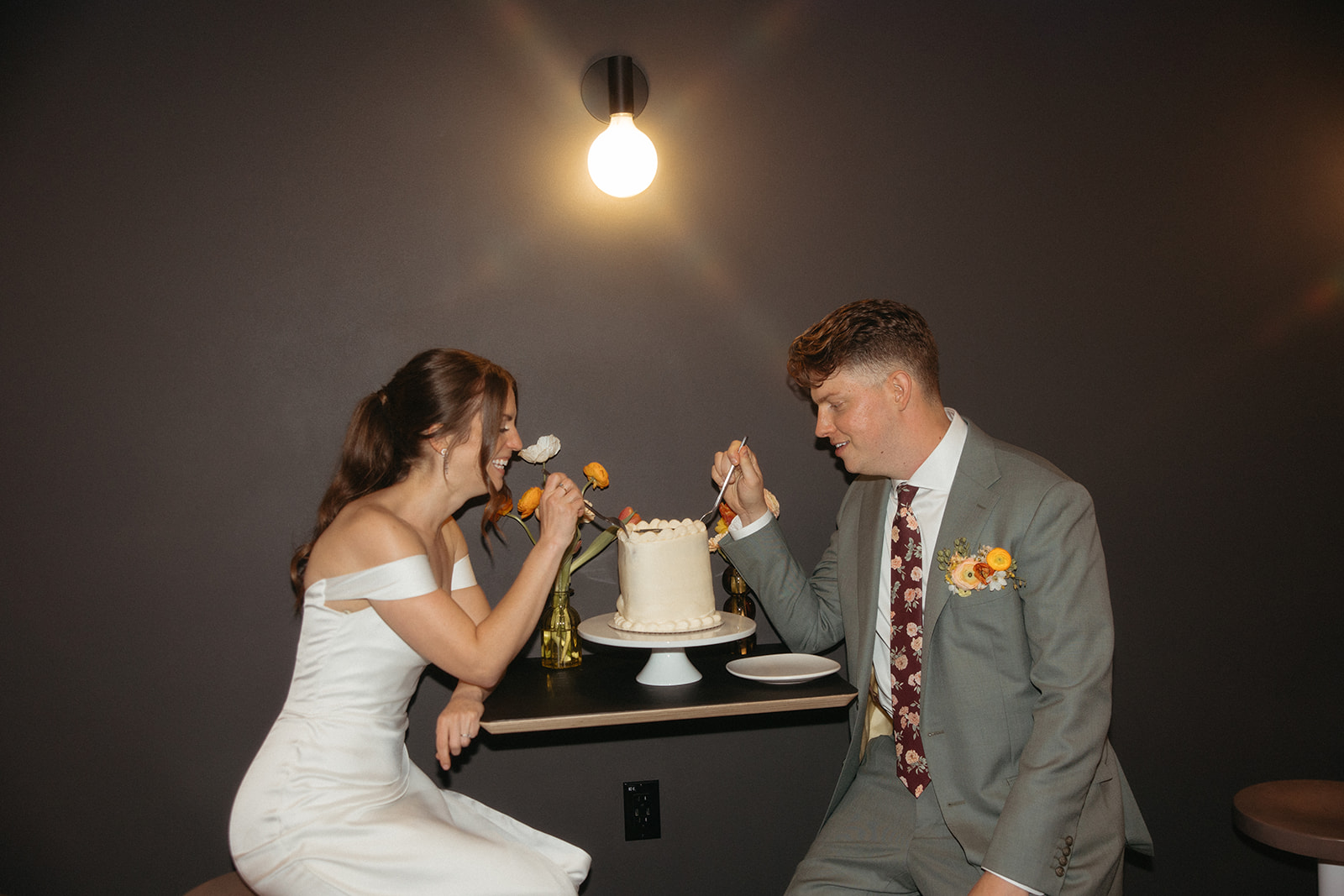 Bride and groom digging into their wedding cake