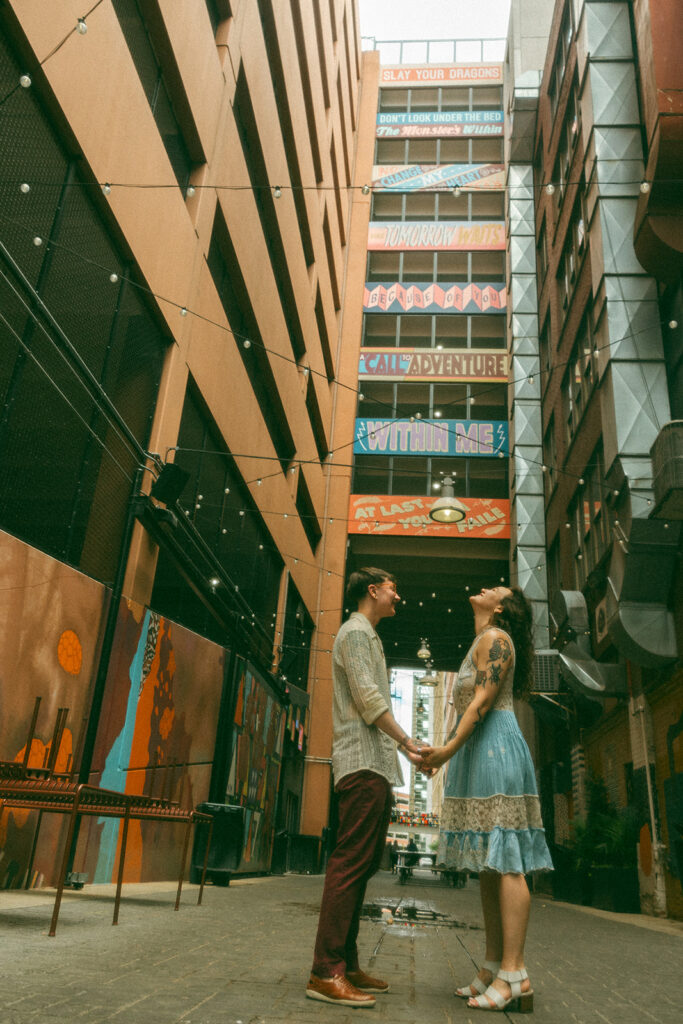 Couple admiring the tall buildings in The Belt Alley in downtown Detroit