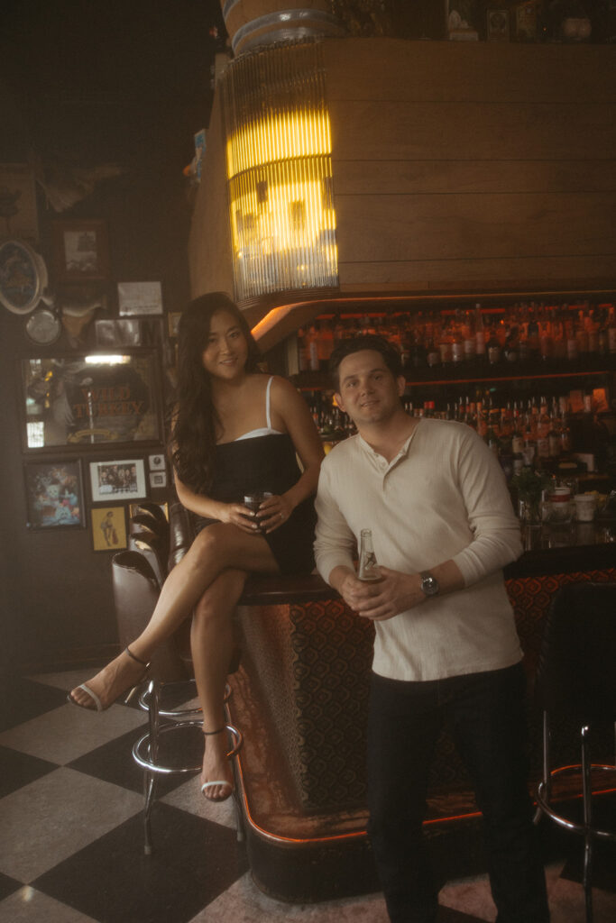 Couple sitting at a bar for their engagement shoot