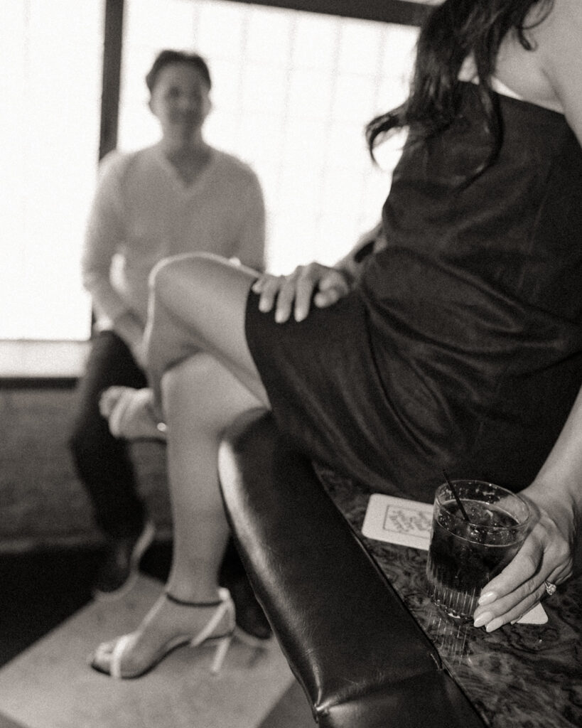 Black and white engagement photo at a bar