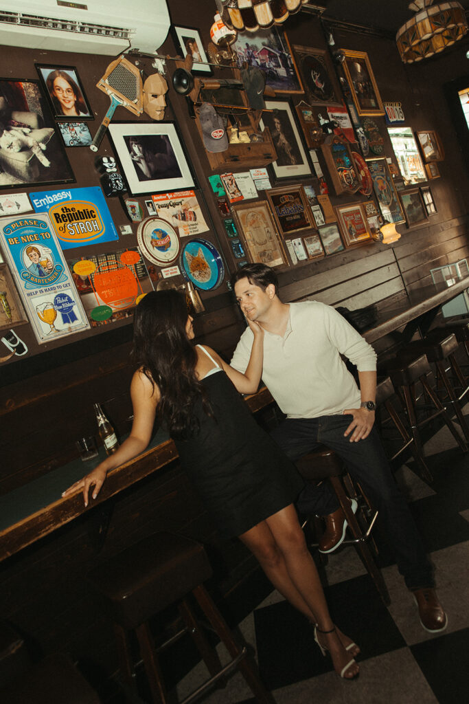 Man and woman posing for their Chicago engagement photos at a bar