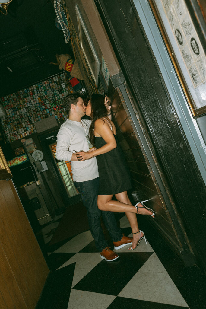 Couple kissing during their bar engagement photos in downtown Chicago