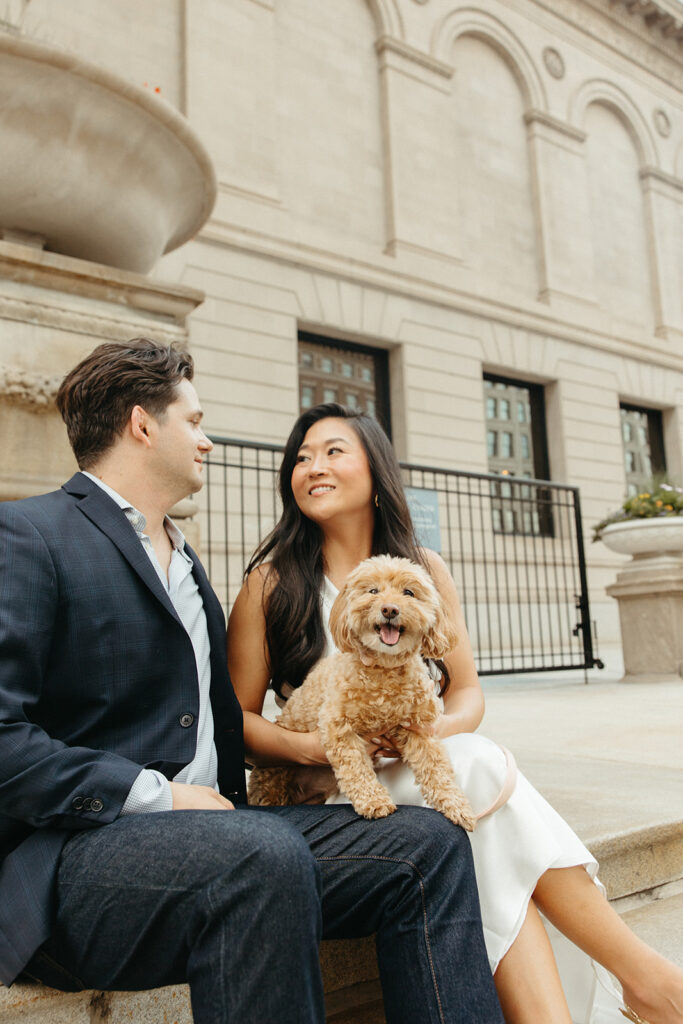 Couple posing outside of the Art Institute of Chicago with their dog