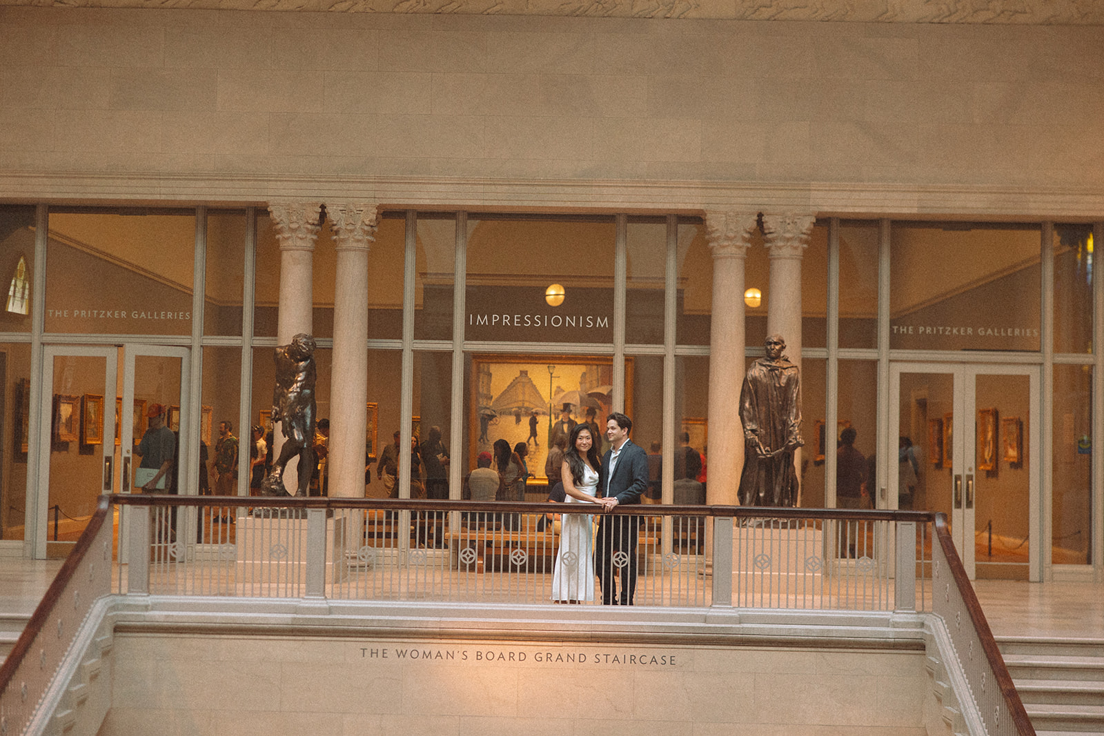 Couple posing on the grand staircase for their Chicago engagement photos at the Art Institute of Chicago