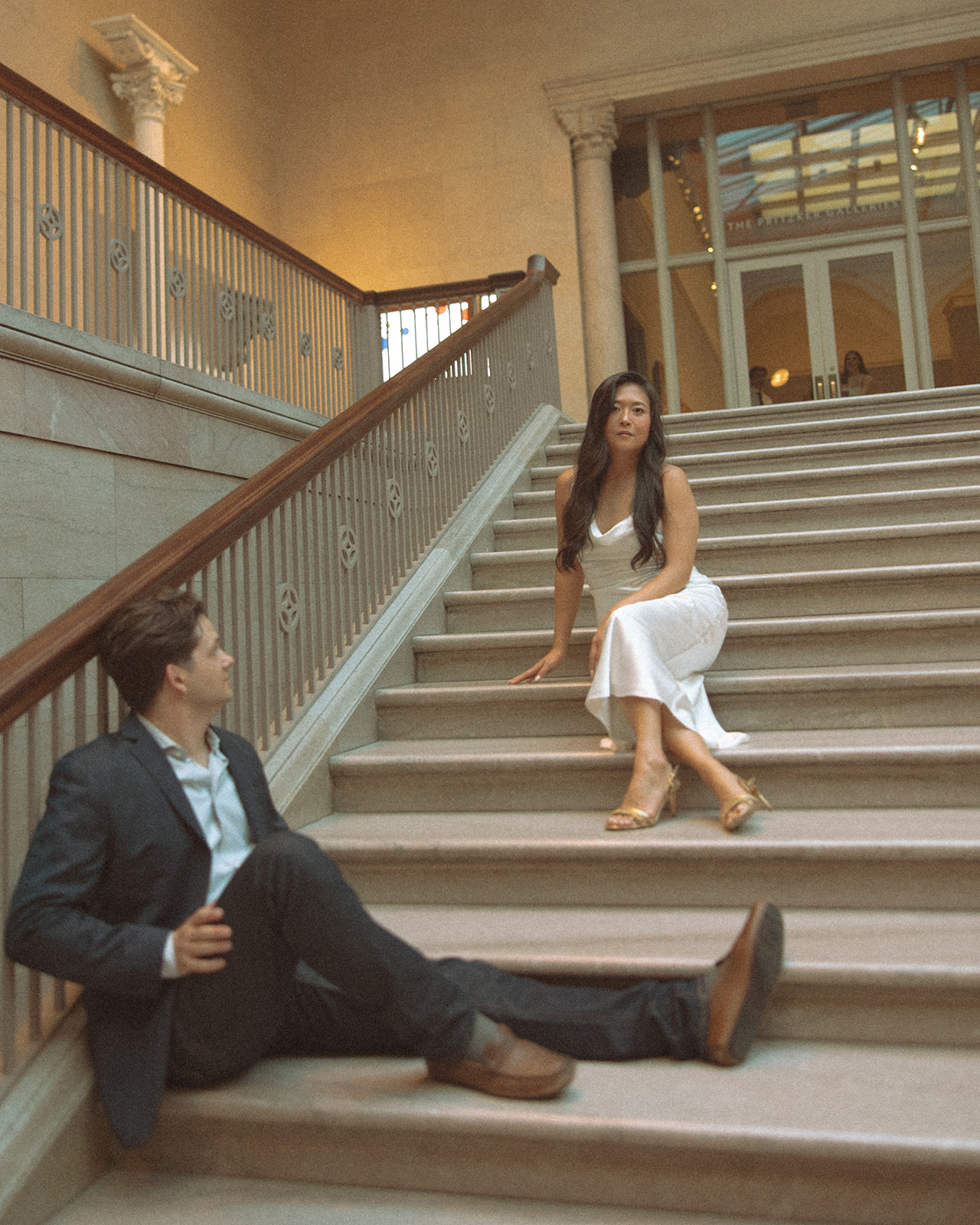 Couple sitting on the grand staircase for their Chicago engagement photos at the Art Institute of Chicago