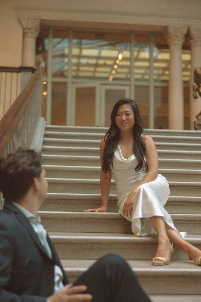 Couple sitting on the grand staircase for their Chicago engagement photos at the Art Institute of Chicago