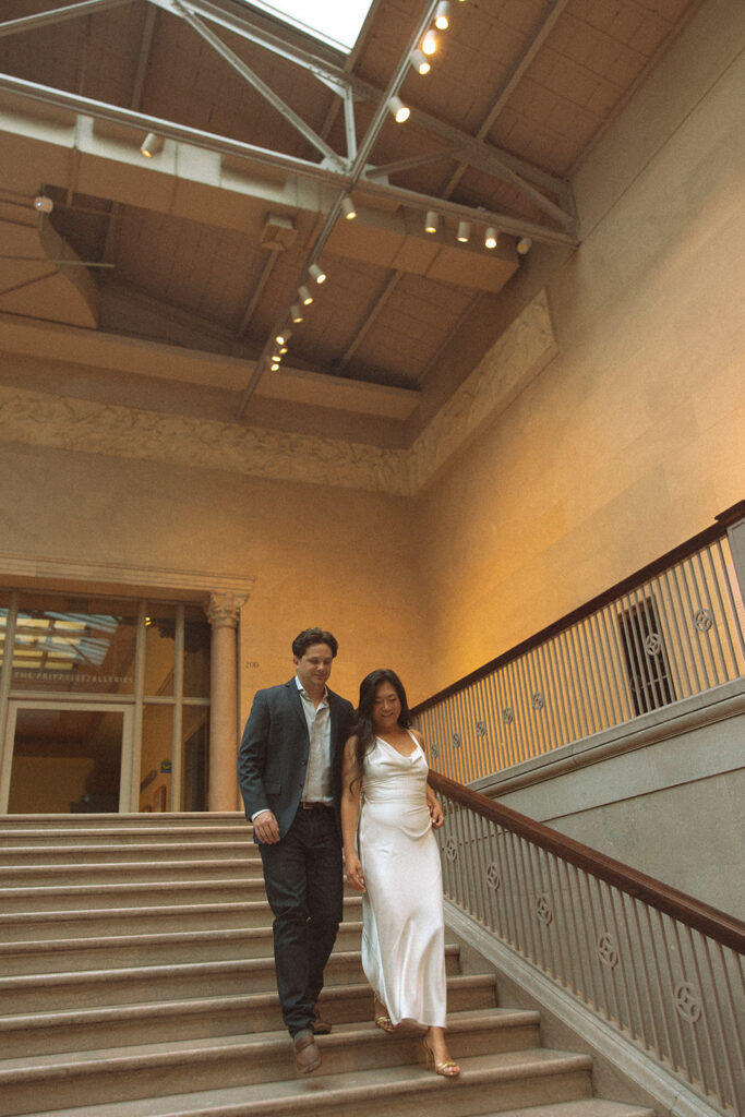 Couple walking down the grand staircase for their Chicago engagement photos at the Art Institute of Chicago