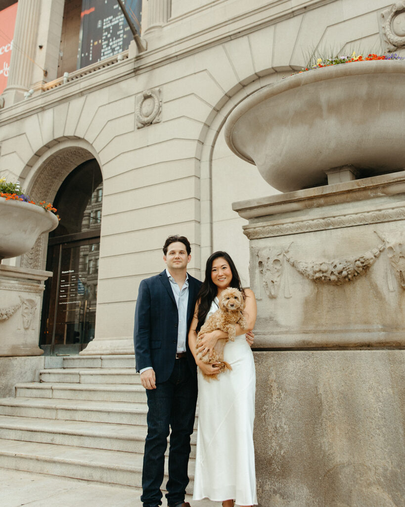 Couple posing outside of the Art Institute of Chicago with their dog