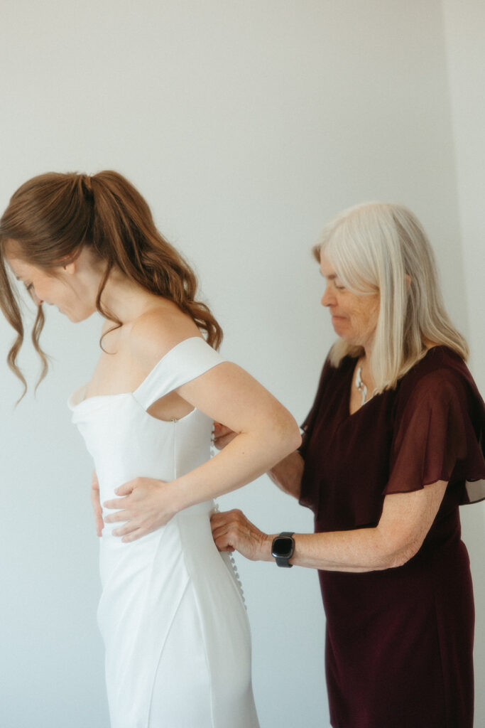 Bride getting her dress zipped up