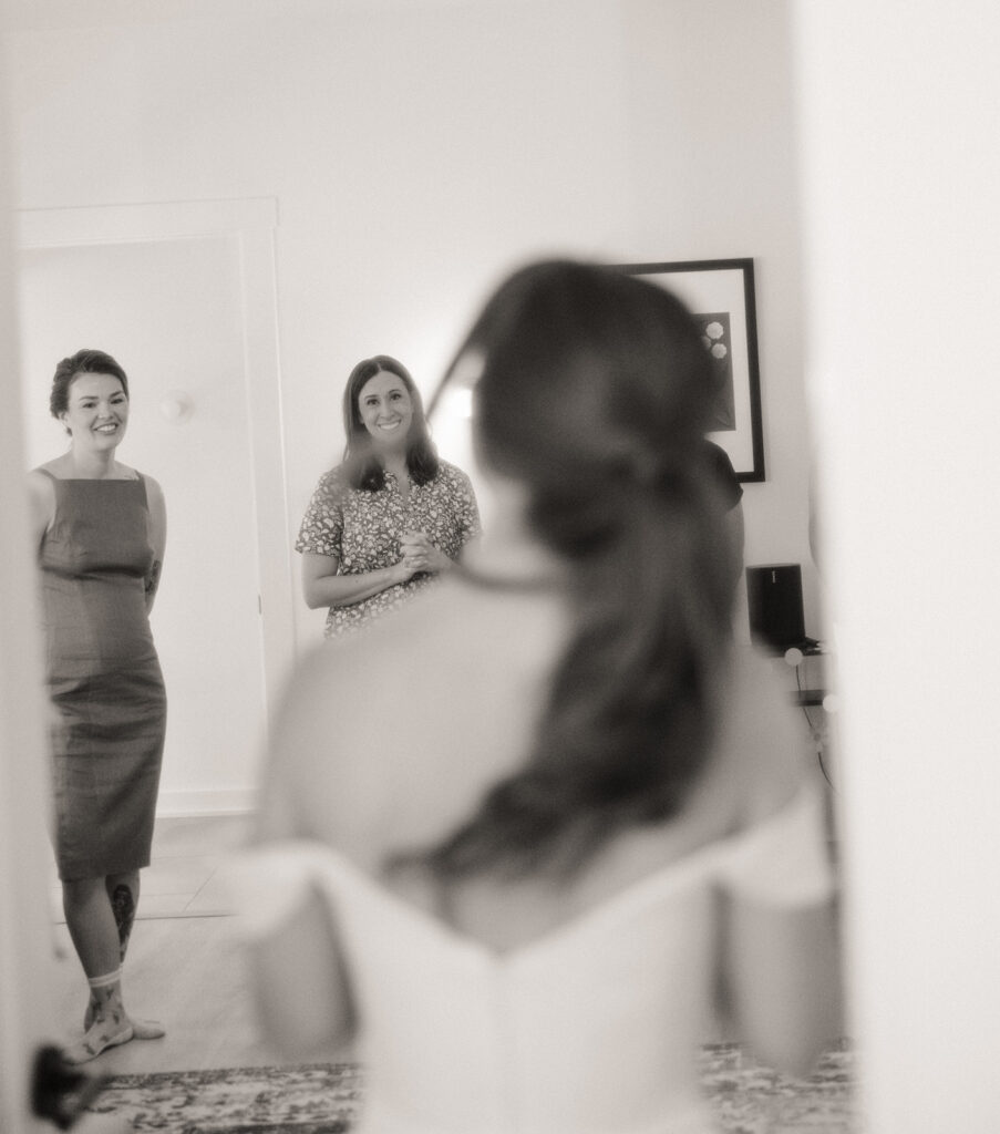 Black and white photo of a bride showing friends and family her bridal look