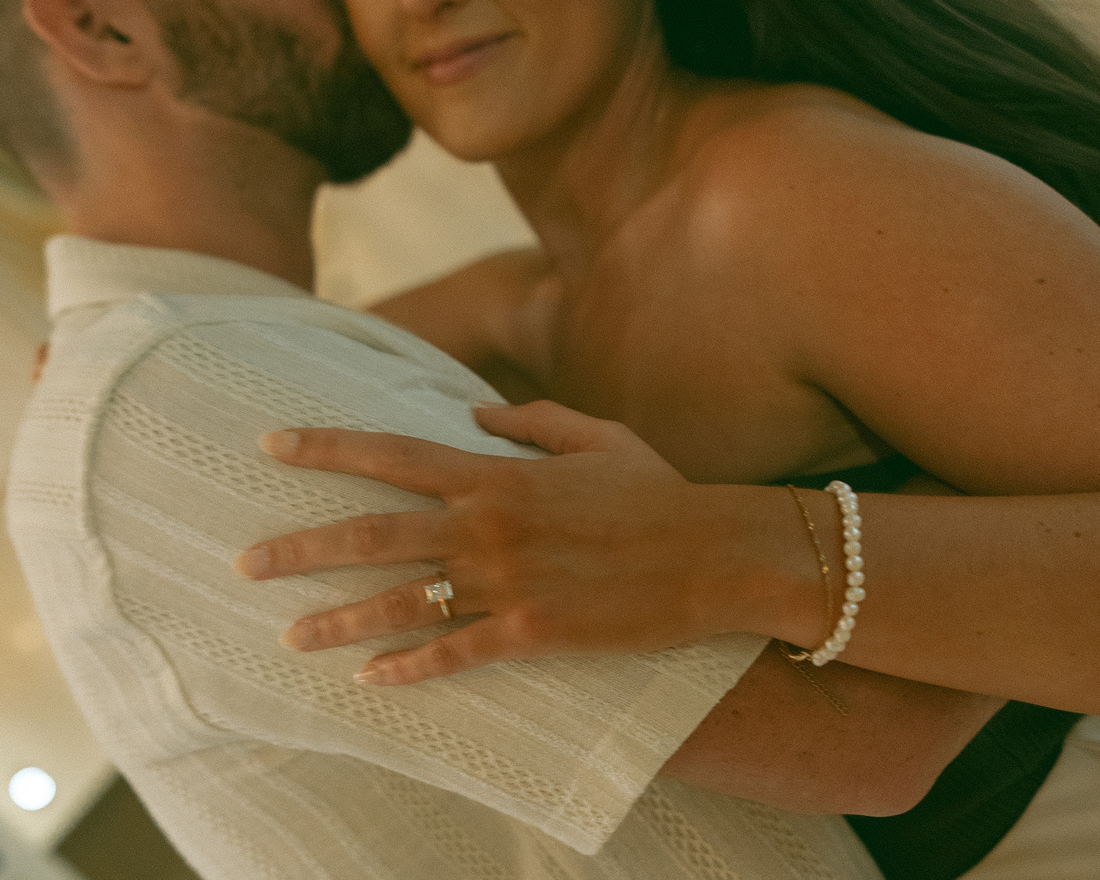 Close up shot of a man kissing his fiancé on the cheek