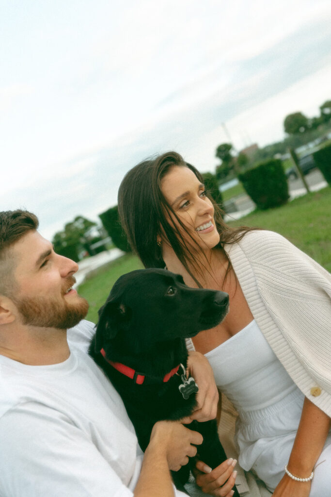 Couple sitting in the grass with their dog at Belle Isle in Detroit, MI