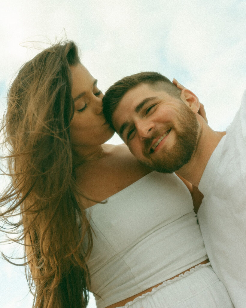 Woman kissing the top of her fiancés head