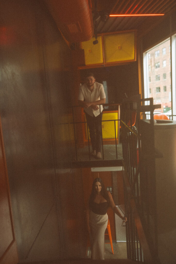 Man and woman posing at a bar