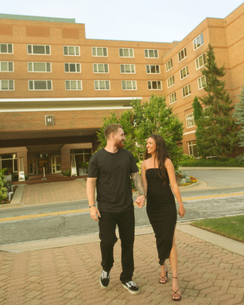 Couple walking in front of The H Hotel in Michigan, MI