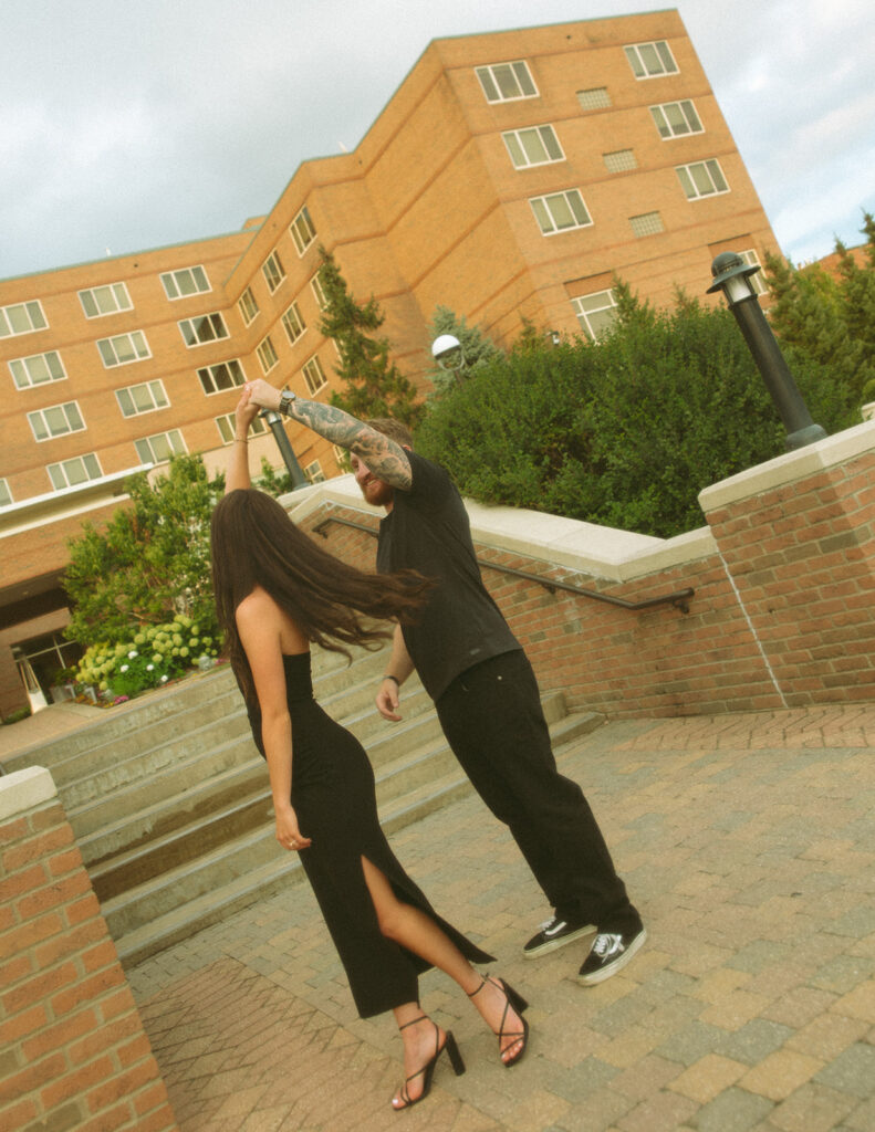 Man twirling his fiancé during their engagement shoot