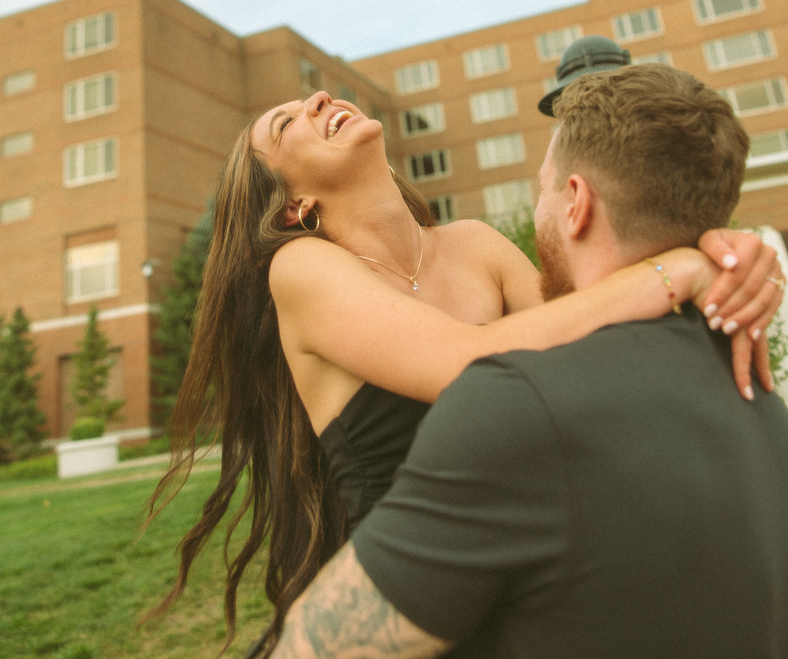 Man picking up his fiancé during their Midland engagement photos outside of The H Hotel