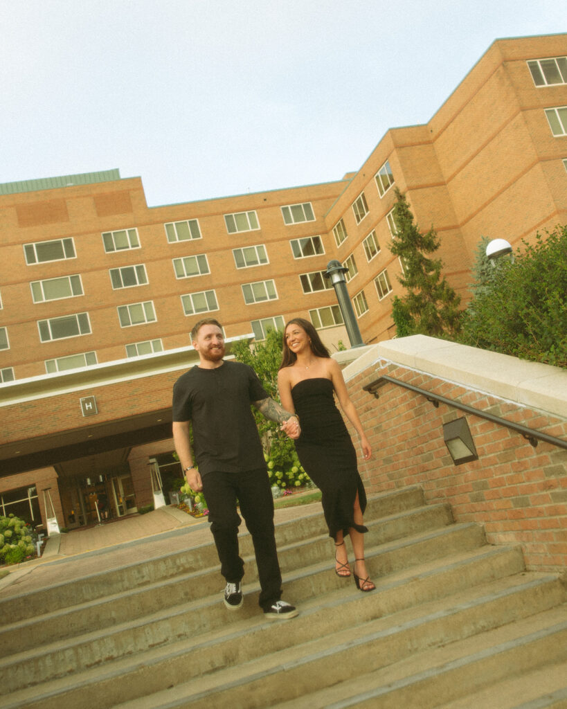 Couple holding hands and walking down stairs for their Midland, Michigan engagement photos