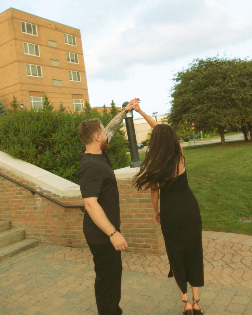 Man twirling his fiancé during their Midland engagement photos in Michigan