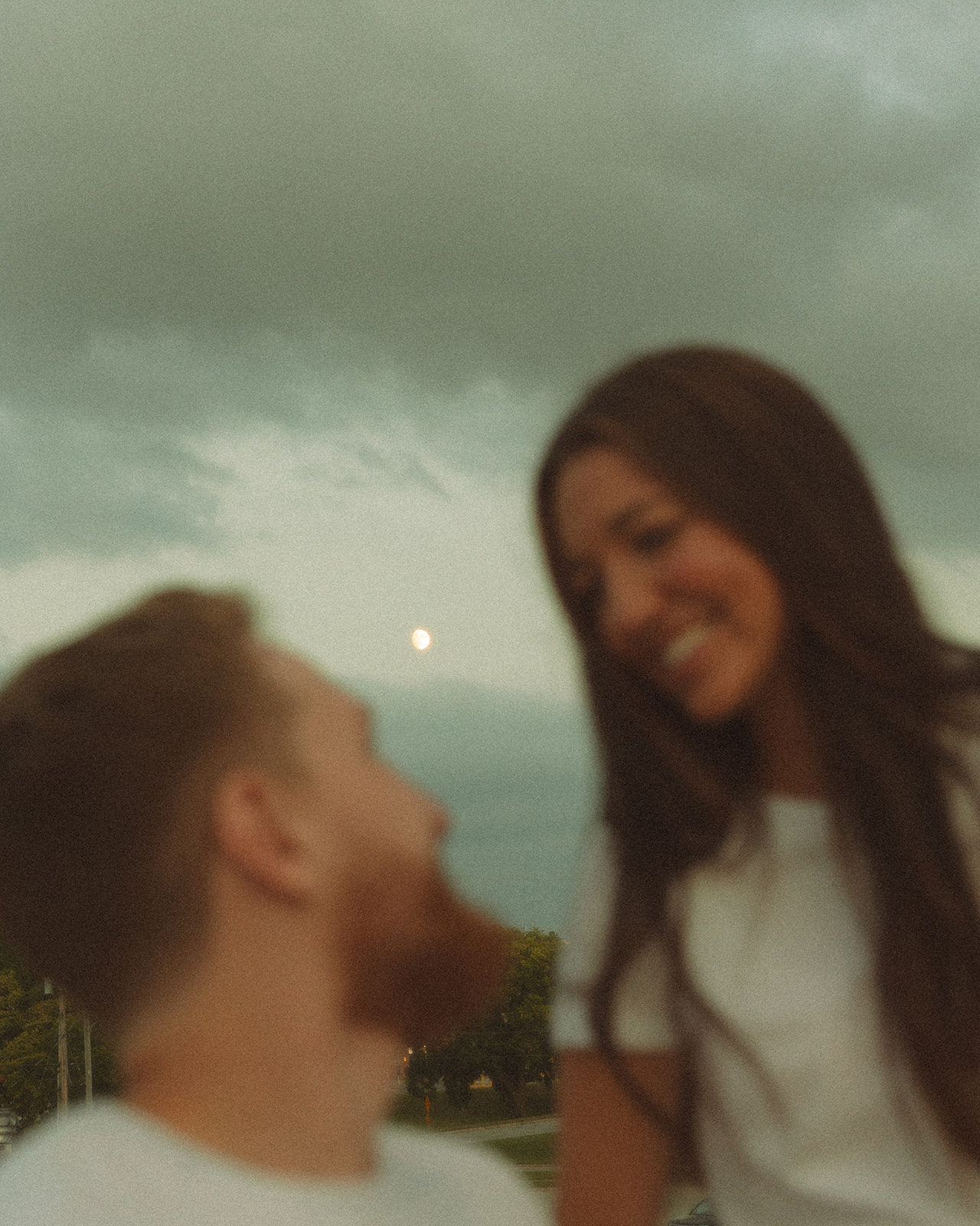 Couple looking at each other with the moon in the background