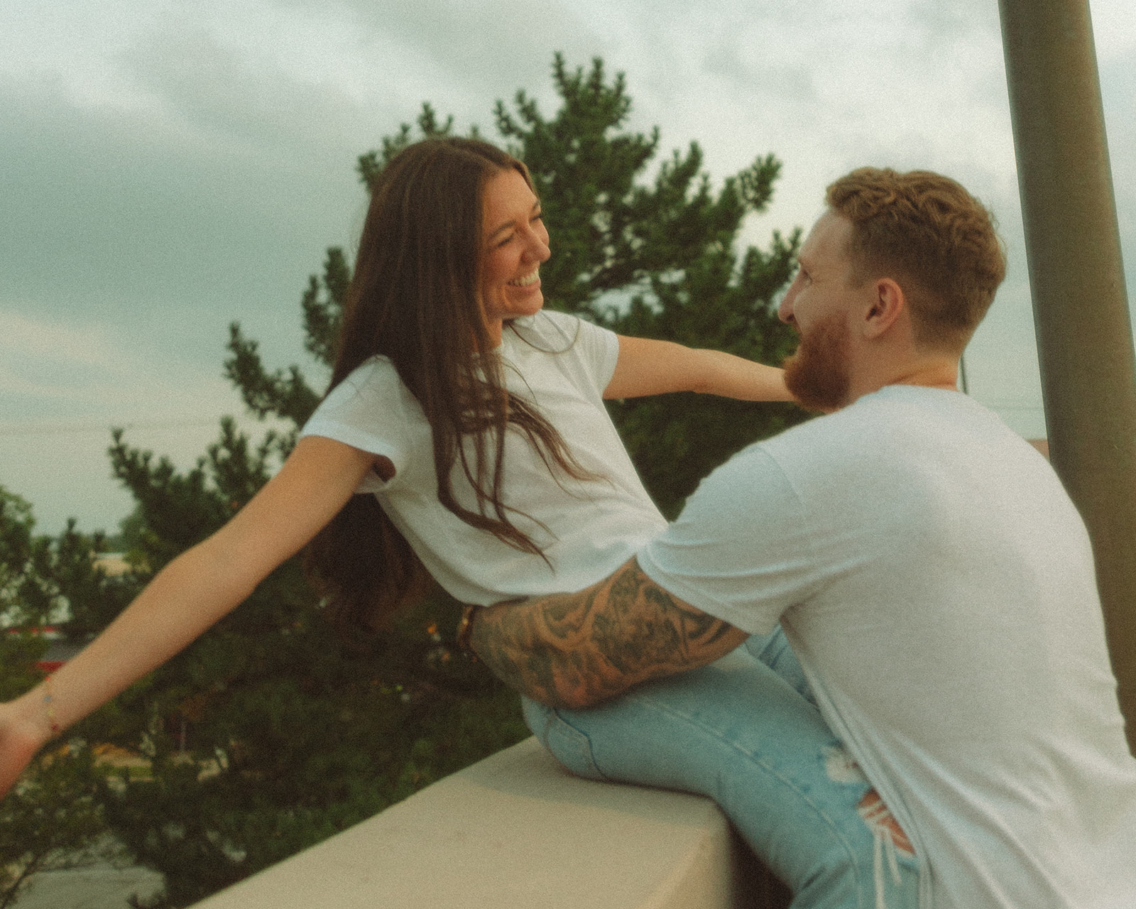 Couple being playful during their rooftop engagement session in Mid Michigan