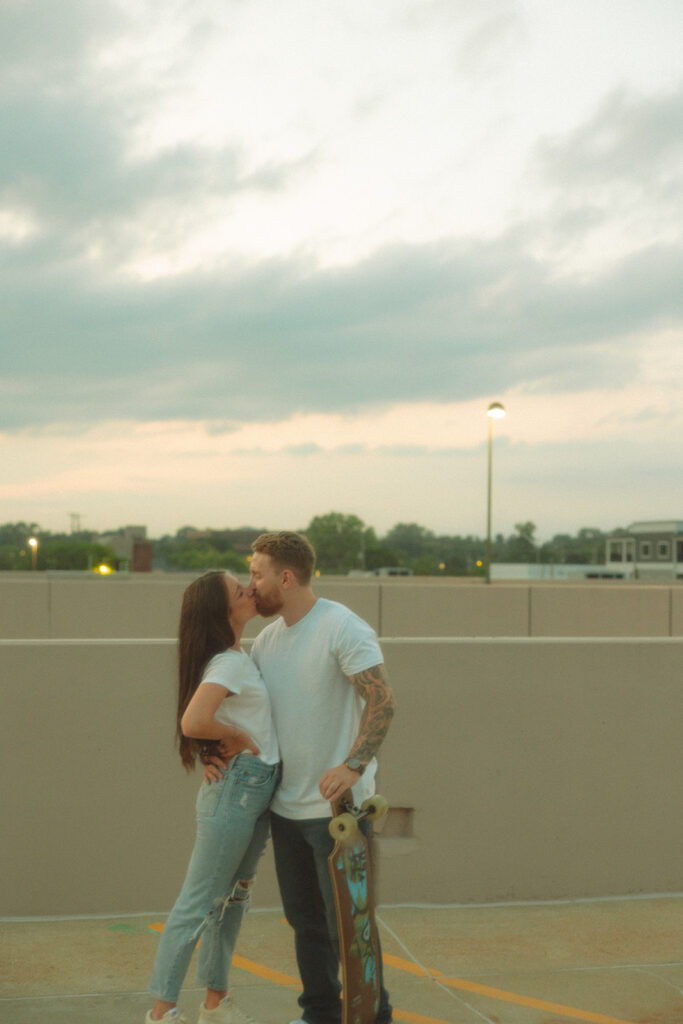 Couple kissing on top of a rooftop parking garage