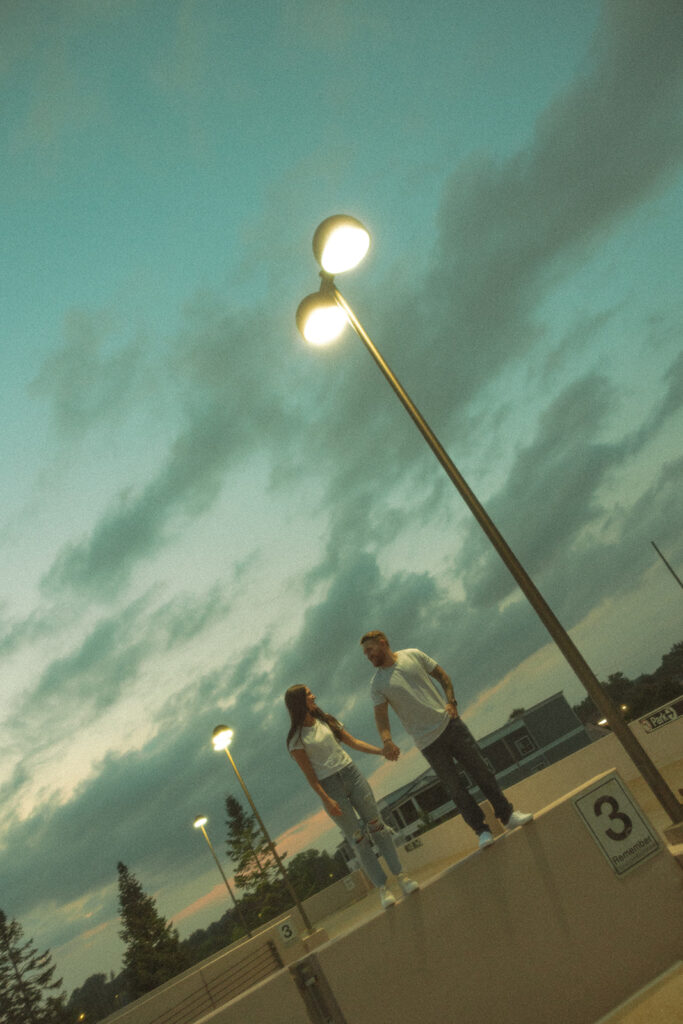 Couple holding hands on a rooftop parking garage in Midland, Michigan