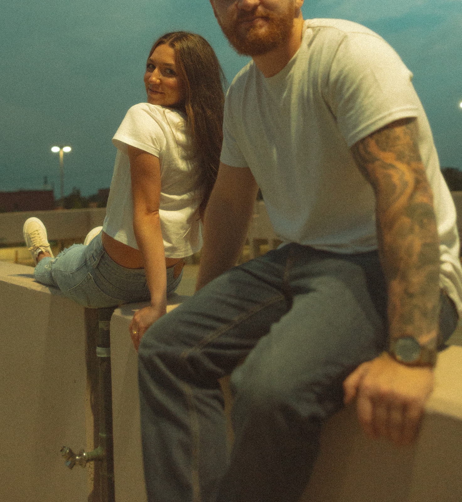 Couple posing on a rooftop parking garage for their Midland, Michigan engagement photos