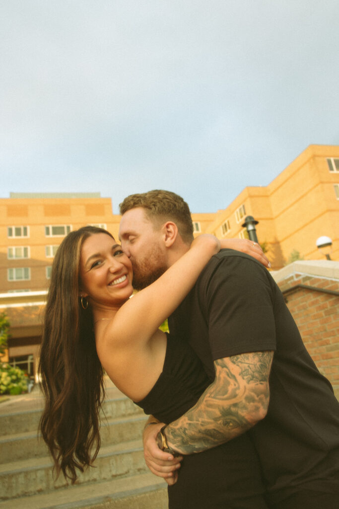 Couple posing in front of The H Hotel in Midland, Michigan for their engagement photos