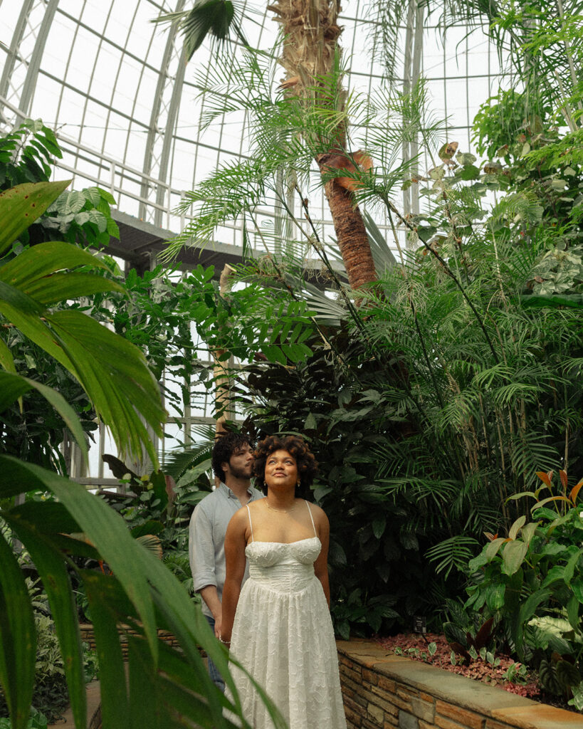 Couple walking through The Conservatory at Belle Isle for their Detroit engagement photos.
