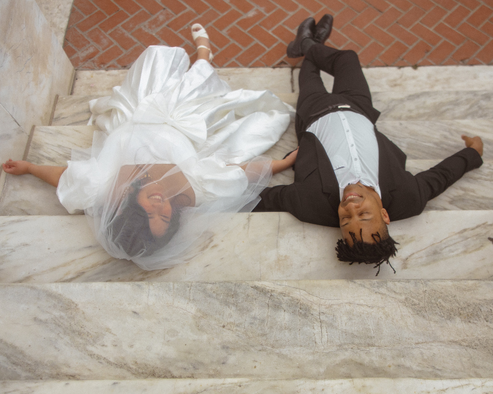 Overhead shot of a couple laying on the stairs at Detroit Institute of Art.
