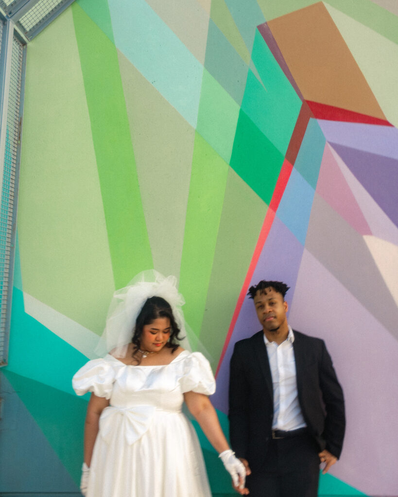 Couple posing in front of a colorful mural on Z Lot in Detroit.