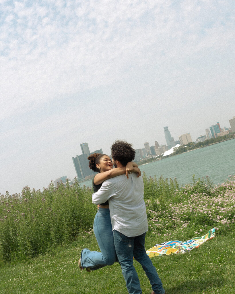 Man picking up his finance during their Detroit engagement photos at Belle Isle.